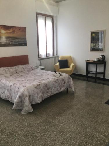 sypialnia z łóżkiem, krzesłem i oknem w obiekcie La Rosa Dei Venti w mieście Finale Ligure