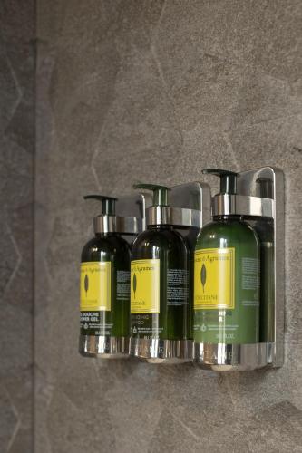three bottles of hair products on a wall at Hotel Tayko Bilbao in Bilbao