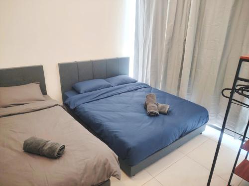 ein Schlafzimmer mit zwei Betten mit Schuhen drauf in der Unterkunft Sweet Stay in Jelutong