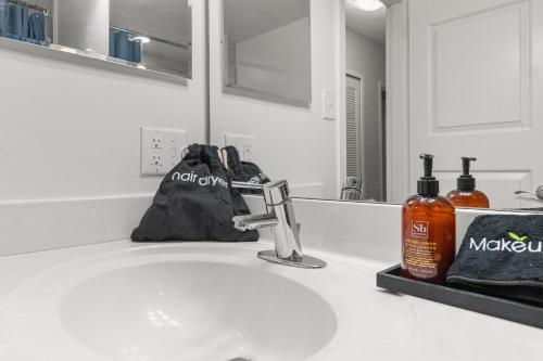 a bathroom sink with a black bag and a mirror at DC Luxury Apartment Near Metro in Arlington