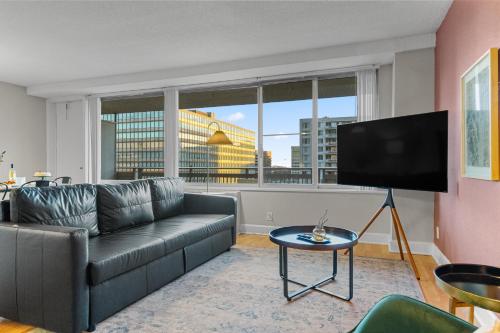 a living room with a couch and a flat screen tv at DC Luxury Apartment Near Metro in Arlington