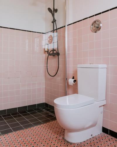a bathroom with a toilet and a shower with pink tiles at Quinta da Quinhas in Vila Praia de Âncora