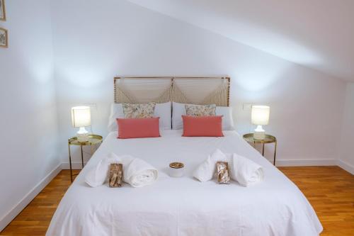 a bedroom with a white bed with two lamps at El Deseo del Carmen in El Burgo de Osma