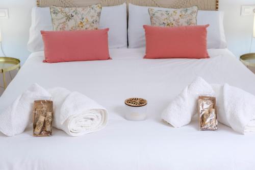 - un lit blanc avec des serviettes et des bougies dans l'établissement El Deseo del Carmen, à El Burgo de Osma