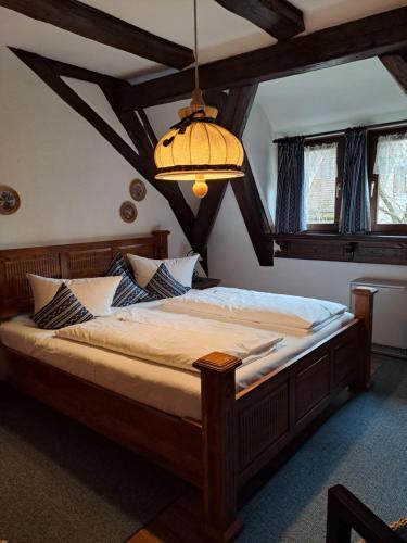 a bedroom with a large bed with a chandelier at Altfraenkische Weinstube in Rothenburg ob der Tauber