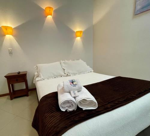 a hotel room with a bed with towels on it at Hotel Oasis de la villa in Villa de Leyva