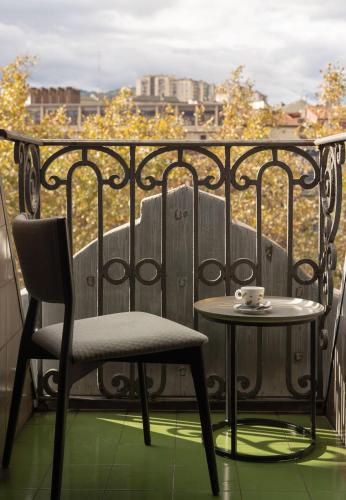 a table and chair on a balcony with a cup of coffee at Hotel Tayko Bilbao in Bilbao