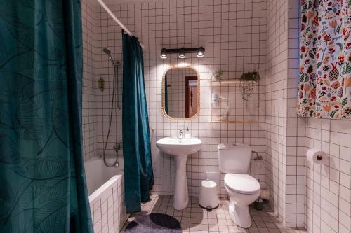a bathroom with a sink toilet and a mirror at Rezident in Bucharest