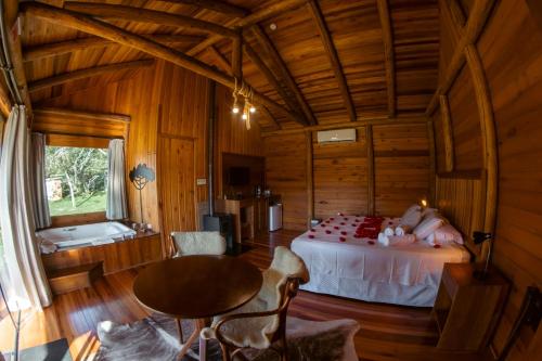 a bedroom with a bed in a wooden cabin at Hospedaria Refugio do Invernador in Urubici