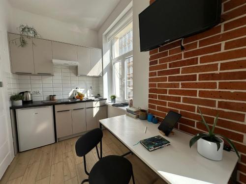 une cuisine avec un mur en briques et un comptoir avec des chaises dans l'établissement Salwator Residence, à Cracovie