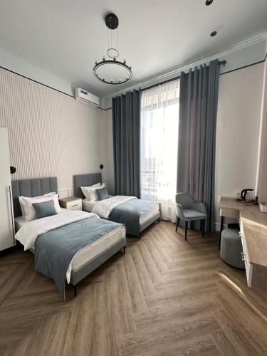Five Hotel في Prigorodnyy: غرفة فندقية بسريرين ومكتب