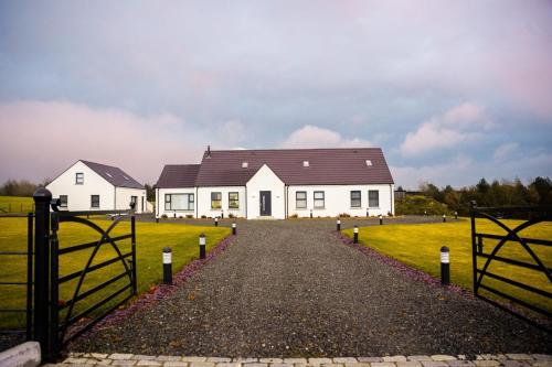 a white house with a black roof in a field at Newtown House in Newry