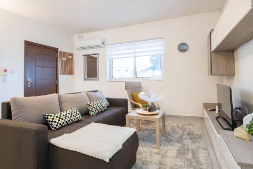 a living room with a couch and a tv at LA88 Sweet Home in San Ġwann