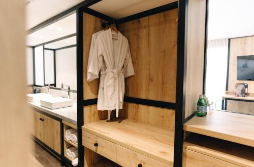 a bathroom with a white robe hanging on a wall at LUOXO Hotel in Lima