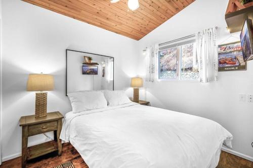 a white bedroom with a bed and a window at Beautiful Cabin Right next to Lake Okanagan #5 in West Kelowna
