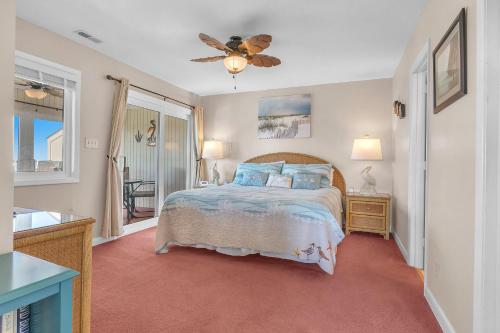 a bedroom with a bed and a ceiling fan at Sea-Nic View in Caswell Beach