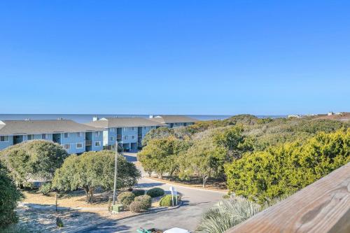 an aerial view of a apartment complex with trees and a road at Sea-Nic View in Caswell Beach