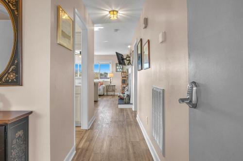 a hallway with white walls and wood floors and a door at Sea-Nic View in Caswell Beach