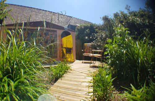 einen hölzernen Gehweg mit gelber Tür im Garten in der Unterkunft La Cour d'Hortense in Sally