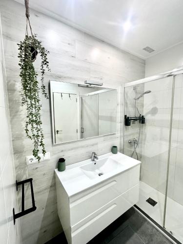 a white bathroom with a sink and a mirror at Casa Únic - Moderno Alojamiento en Ruzafa in Valencia
