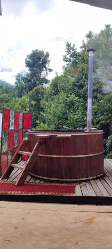 eine Holzterrasse mit einem Holztisch darüber in der Unterkunft Cabaña con tinaja El Arrayán in Lago Ranco