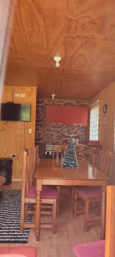 ein Esszimmer mit einem Holztisch und Stühlen in der Unterkunft Cabaña con tinaja El Arrayán in Lago Ranco