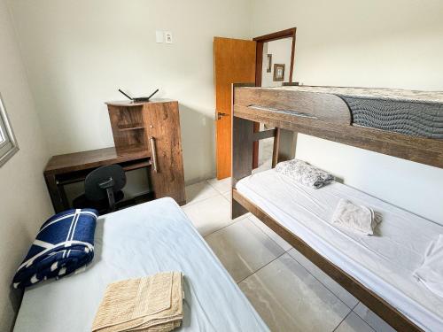 a room with two bunk beds and a desk at 207- APARTAMENTO de 2 QUARTOS no ALTO CAIÇARAS in Patos de Minas