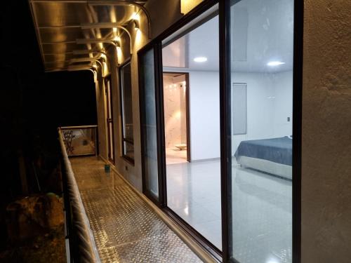 una ventana con vistas a un dormitorio y una cama en Casa 39 Treviso, en Arbeláez