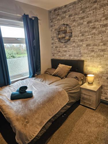 a bedroom with a bed and a brick wall at Tudor Road House in Leicester