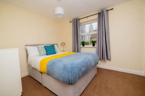 um quarto com uma cama e uma janela em Charming 4-bedroom home in Corby em Great Oakley