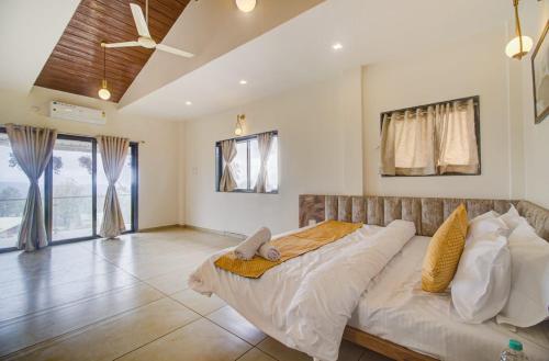 OCEAN CREST LUXURY VILLA Mahabaleshwar في ماهاباليشوار: غرفة نوم بسرير كبير في غرفة ذات سقف