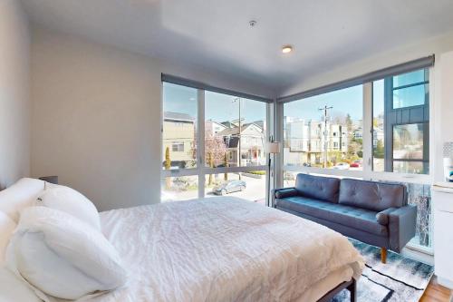 a bedroom with a bed and a couch and a large window at Marion Place in Seattle
