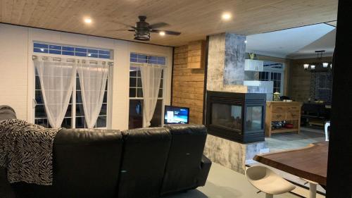 een woonkamer met een bank en een open haard bij Gîte des étoiles in Notre-Dame-Des-Bois