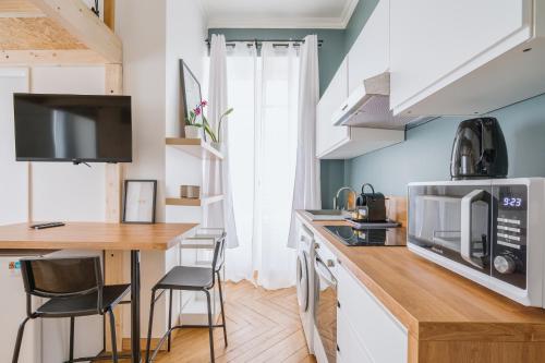 Il comprend une cuisine équipée d'un four micro-ondes et d'une table avec des chaises. dans l'établissement Studio Vichy célestin Villa Marie Celine, à Vichy