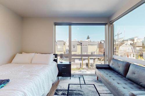 a bedroom with a bed and a couch and a large window at Marion Hideaway in Seattle