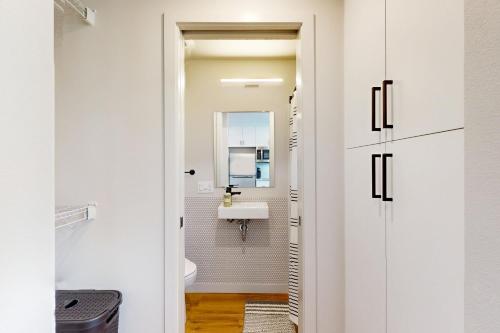 a white bathroom with a sink and a mirror at Marion Hideaway in Seattle