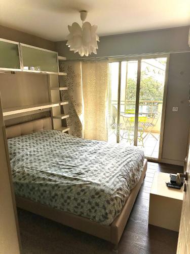 une chambre avec un lit et un lustre dans l'établissement Résidence Californie Cannes, à Cannes