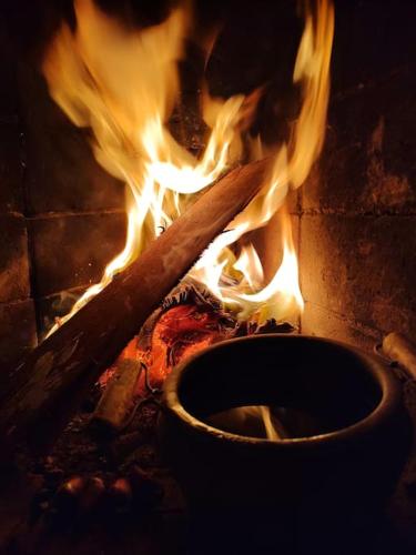 a pot on fire next to a pot on a stove at Casa Mohini Refúgio nas montanhas de Teresópolis Quarto com deck rede suspensa lareira cachoeira e piscina in Teresópolis