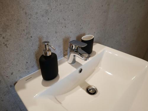 a bathroom sink with a black soap dispenser on it at Boutique Hotel in Bad Salzuflen