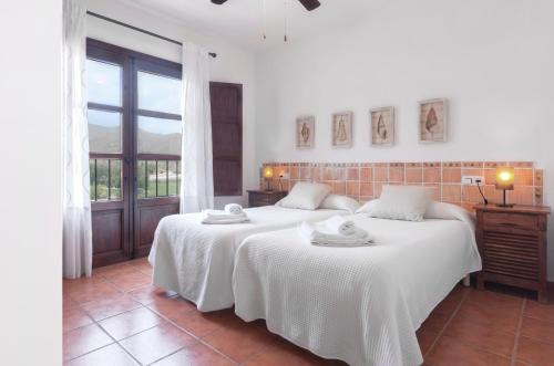 a bedroom with two beds with white sheets at Casa Piedra Galera - San José in San José