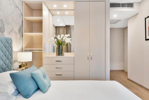 a bedroom with a white bed with a blue pillow at Hotel Excelsior in Marina di Massa