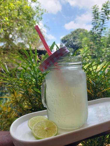 a mason jar of lemonade with a slice of lime at Dad's Holiday Home in Matale