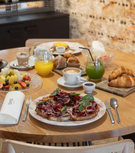 a wooden table with a plate of food on it at Hotel Tayko Bilbao in Bilbao