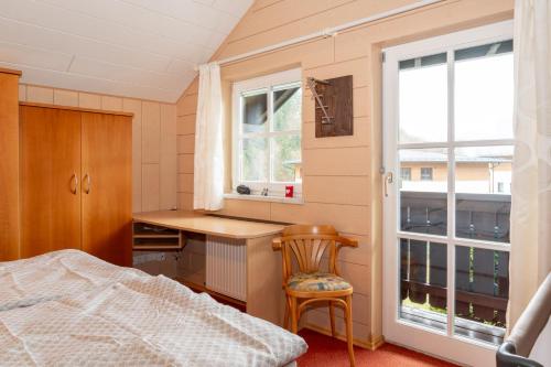 um quarto com uma cama, uma secretária e uma janela em Chalet Lercher em Goldegg