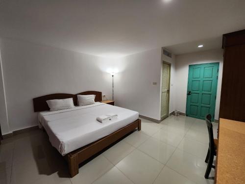 1 dormitorio con cama y puerta verde en Baanmai Residence, en Ban Krabi Yai