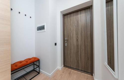 a hallway with a wooden door and a wooden floor at Люкс на Бориспільській ЖК Олімпік Парк, генератор на будинку in Kyiv