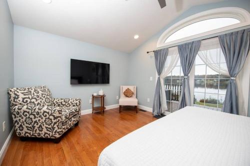 a bedroom with a bed and a chair and a window at Pet friendly with Fireplace, Near Kasoag Snow Trail in Altmar