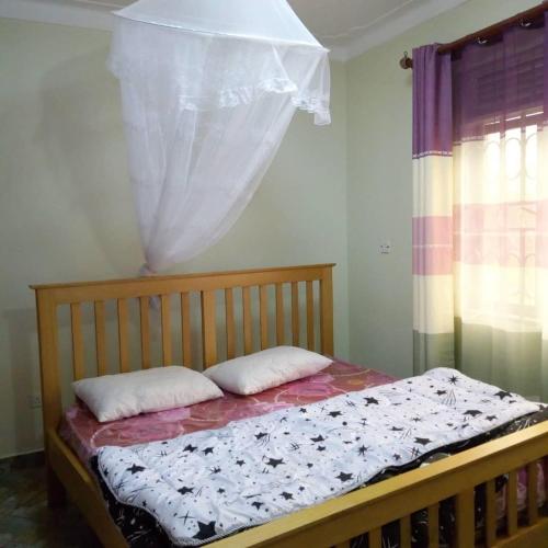 een bed met twee kussens in een slaapkamer bij V.S.C Courts in Kampala