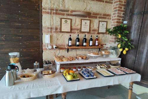 a table with a buffet of food and bottles of wine at Agriturismo Le Tre Rose - Cantina Zanello in Rosignano Monferrato
