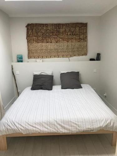 un lit avec deux oreillers dessus dans une chambre dans l'établissement Maison Surf & Nature à Hendaye, à Hendaye